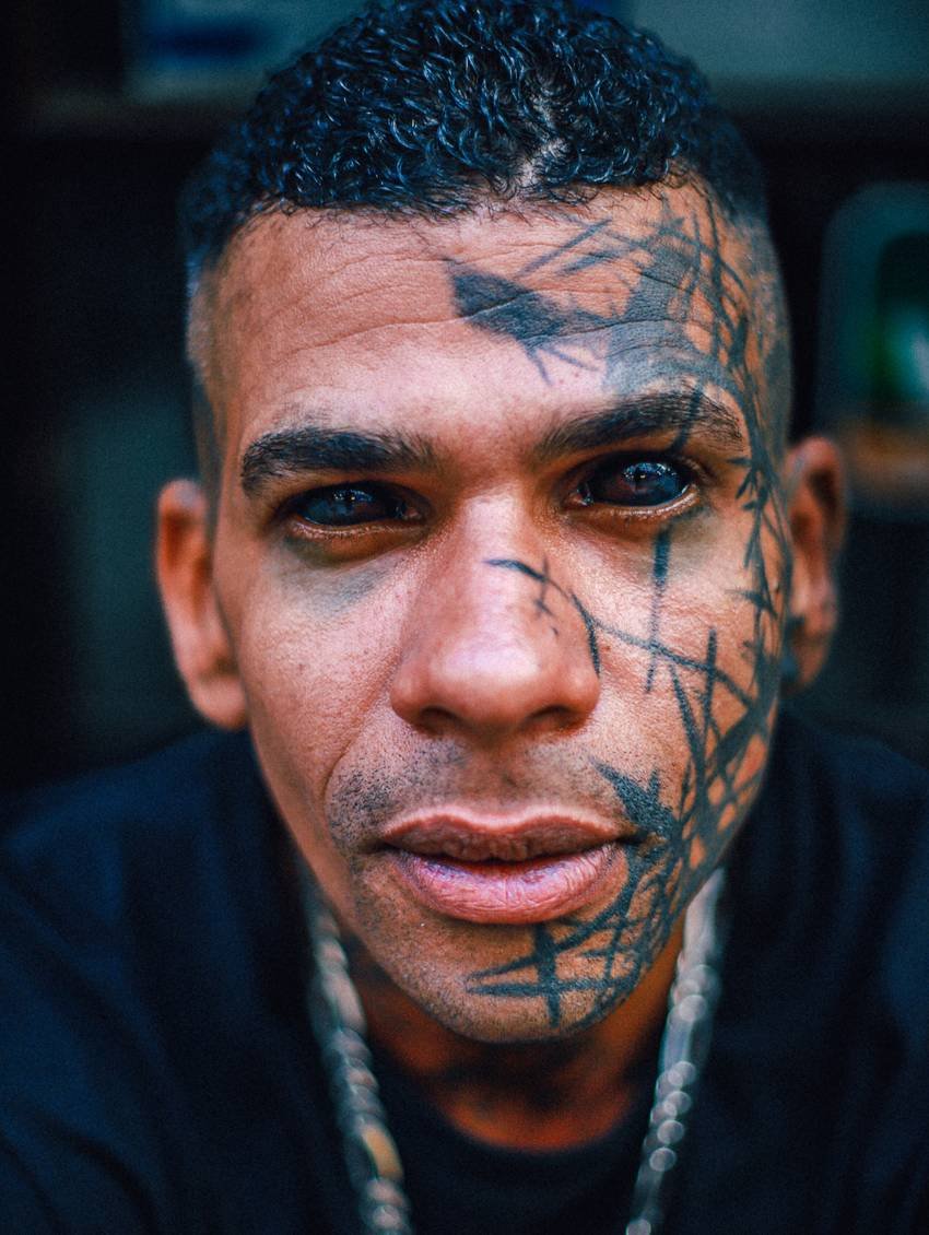 Portret van een man met grafische lijnen over zijn gezicht getatoeëerd