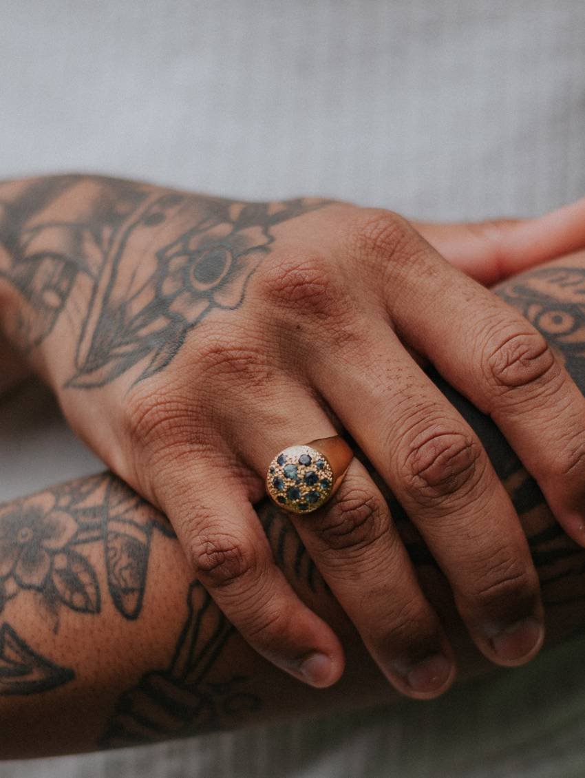 Getatoeëerde handen met fijne bloemmotieven en een ring