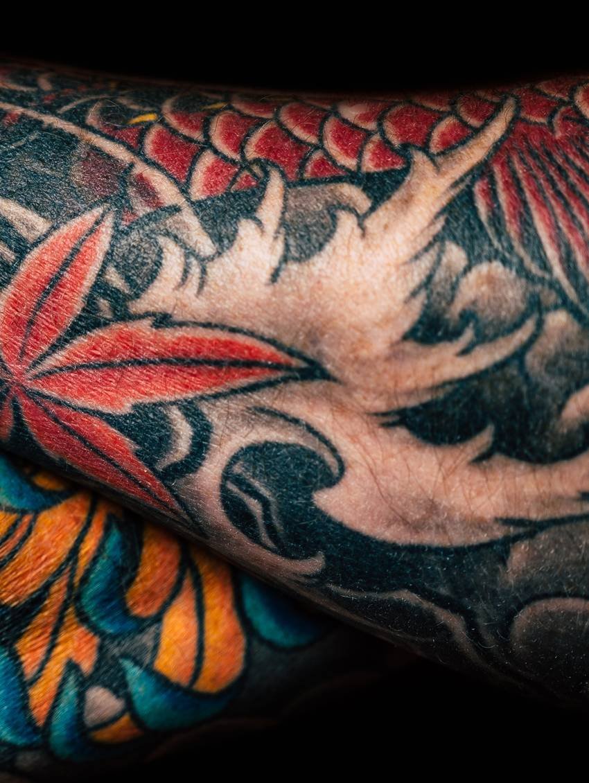 Detail van een Japanse sleeve met rode bladeren en golven in kleur